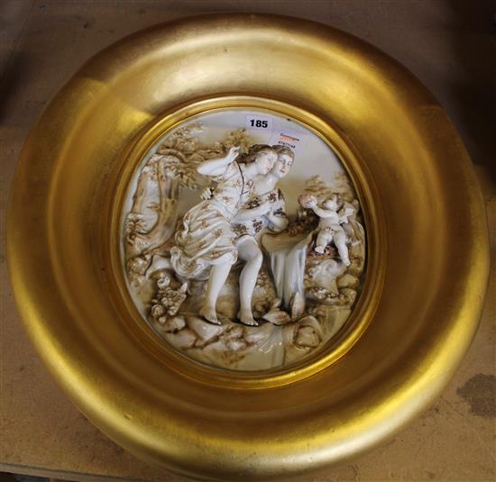A Continental oval gilded porcelain relief with a boy, girl and baby figures, 50cm